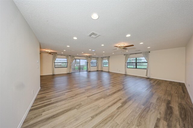 1508 Ingram Dr Unit 20, Sun City Center, FL 33573 - unfurnished living room with a textured ceiling, recessed lighting, ceiling fan, wood finished floors, and baseboards