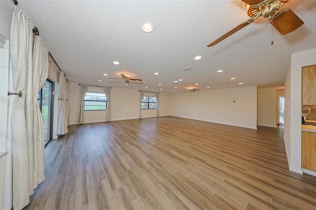 1508 Ingram Dr Unit 20, Sun City Center, FL 33573 - unfurnished living room featuring a ceiling fan, recessed lighting, a textured ceiling, light wood-type flooring, and baseboards