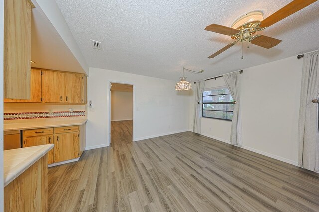 1508 Ingram Dr Unit 20, Sun City Center, FL 33573 - kitchen featuring tile counters, light wood-style floors, a textured ceiling, a ceiling fan, and baseboards
