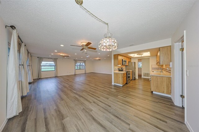 1508 Ingram Dr Unit 20, Sun City Center, FL 33573 - unfurnished living room featuring a textured ceiling, light wood-type flooring, a ceiling fan, recessed lighting, and a sink