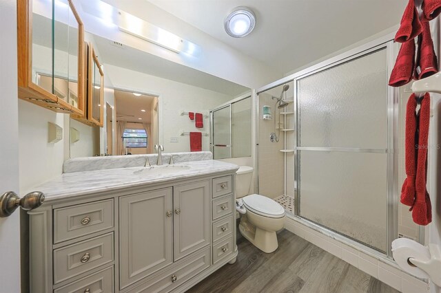 1508 Ingram Dr Unit 20, Sun City Center, FL 33573 - bathroom with toilet, vanity, a shower stall, and wood finished floors