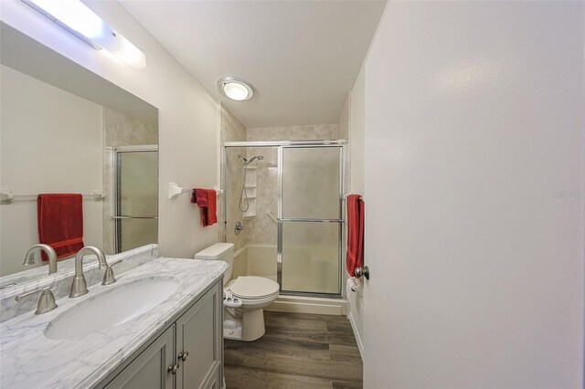 1508 Ingram Dr Unit 20, Sun City Center, FL 33573 - bathroom with toilet, vanity, a stall shower, and wood finished floors