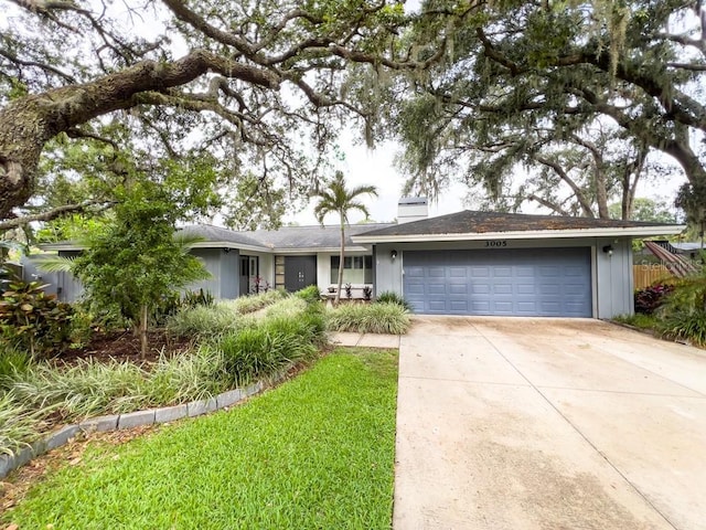 3005 Wilton Ln, Valrico, FL 33596 - ranch-style home with concrete driveway, an attached garage, and a chimney