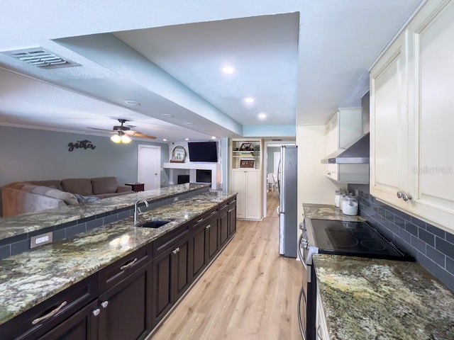3005 Wilton Ln, Valrico, FL 33596 - kitchen with appliances with stainless steel finishes, open floor plan, a sink, light wood-style floors, and backsplash