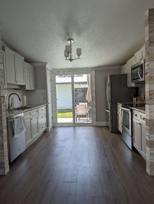 85 Heather Point Ct Unit 850, New Smyrna Beach, FL 32169 - kitchen featuring appliances with stainless steel finishes, a sink, a textured ceiling, dark wood-style flooring, and a chandelier