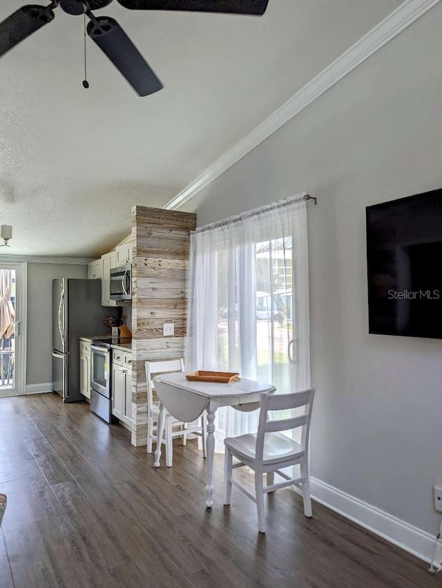 85 Heather Point Ct Unit 850, New Smyrna Beach, FL 32169 - dining space featuring ornamental molding, a ceiling fan, baseboards, dark wood finished floors, and lofted ceiling