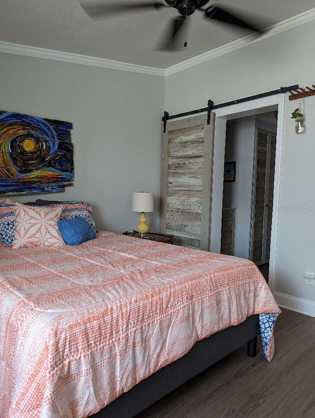 85 Heather Point Ct Unit 850, New Smyrna Beach, FL 32169 - bedroom featuring wood finished floors, crown molding, a barn door, baseboards, and a ceiling fan