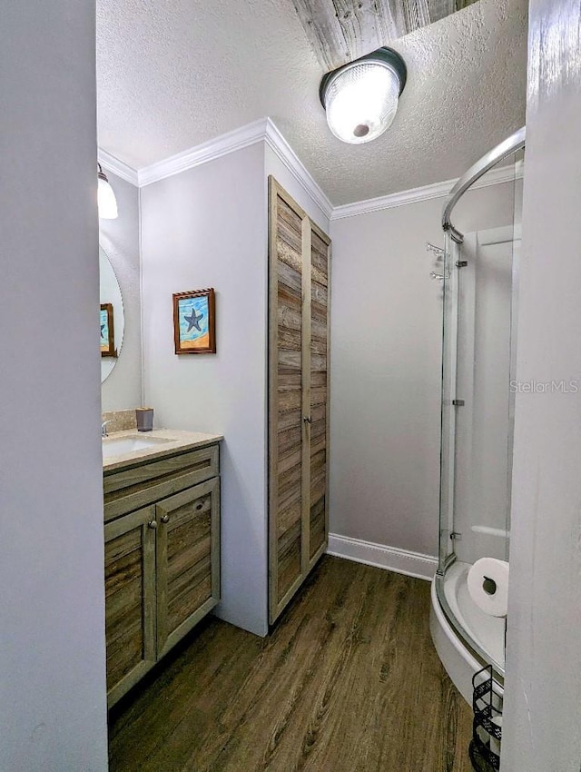 85 Heather Point Ct Unit 850, New Smyrna Beach, FL 32169 - full bathroom with wood finished floors, a stall shower, vanity, a textured ceiling, and crown molding