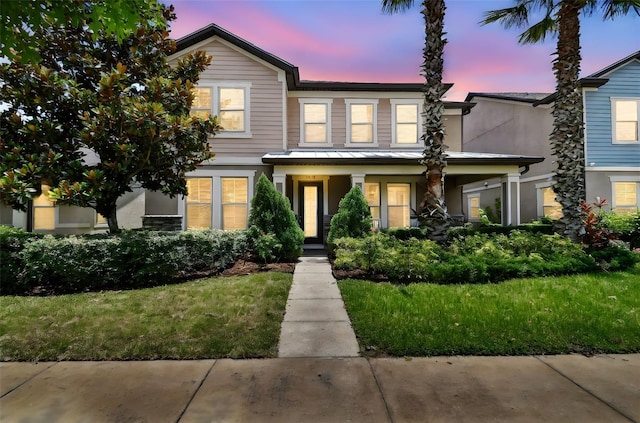 14110 Barrington Stowers Dr, Lithia, FL 33547 - view of front of home with a standing seam roof, stucco siding, a porch, metal roof, and a yard