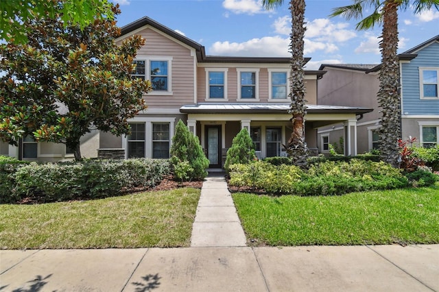 14110 Barrington Stowers Dr, Lithia, FL 33547 - view of front of house with a front lawn, a standing seam roof, metal roof, stucco siding, and a porch