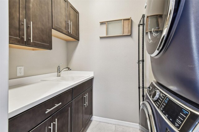 14110 Barrington Stowers Dr, Lithia, FL 33547 - laundry room featuring stacked washing machine and dryer, cabinet space, and baseboards
