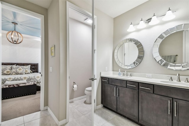 14110 Barrington Stowers Dr, Lithia, FL 33547 - ensuite bathroom with double vanity, toilet, a chandelier, tile patterned flooring, and baseboards