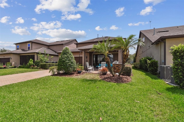 14110 Barrington Stowers Dr, Lithia, FL 33547 - view of front of house featuring decorative driveway, central air condition unit, a front lawn, stucco siding, and an attached garage