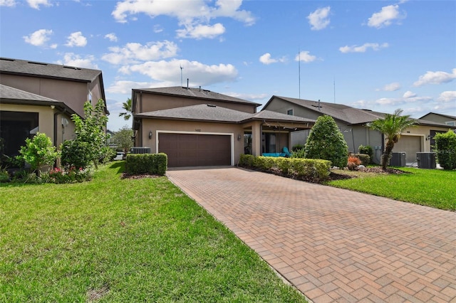 14110 Barrington Stowers Dr, Lithia, FL 33547 - view of front of house with an attached garage, decorative driveway, a front yard, stucco siding, and cooling unit