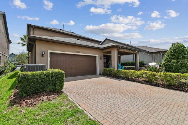 14110 Barrington Stowers Dr, Lithia, FL 33547 - view of front of property with central AC, a garage, decorative driveway, and stucco siding