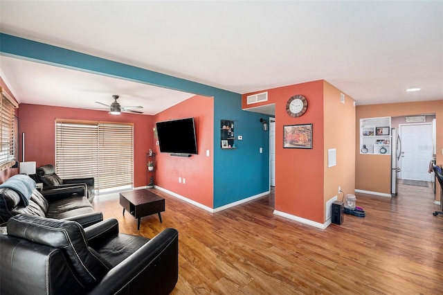 8556 91st Ter, Seminole, FL 33777 - living area featuring light wood-style floors, baseboards, and a ceiling fan
