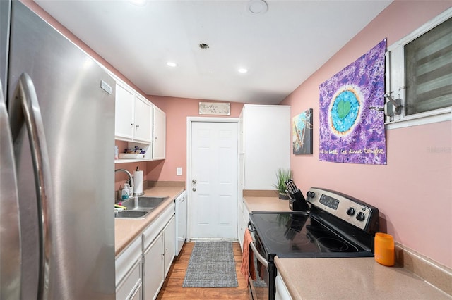 8556 91st Ter, Seminole, FL 33777 - kitchen with stainless steel appliances, a sink, light wood-style flooring, light countertops, and white cabinetry
