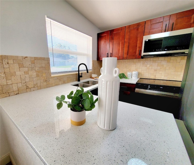 1373 Fairfax Rd, Clearwater, FL 33764 - kitchen with stainless steel microwave, black / electric stove, and decorative backsplash