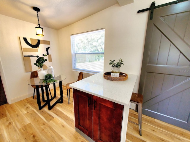 1373 Fairfax Rd, Clearwater, FL 33764 - dining area with a barn door, light wood-style flooring, and lofted ceiling