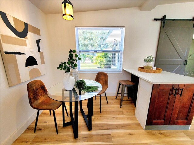 1373 Fairfax Rd, Clearwater, FL 33764 - dining space with a barn door and light wood-style flooring