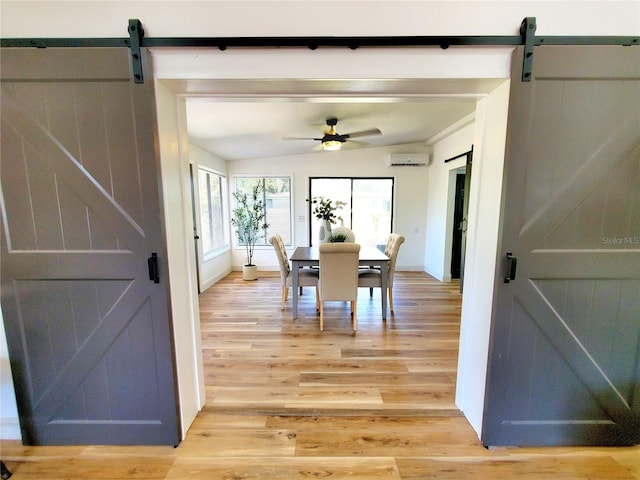 1373 Fairfax Rd, Clearwater, FL 33764 - dining area with a barn door, an AC wall unit, and light wood-style flooring