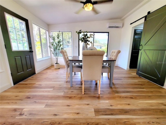 1373 Fairfax Rd, Clearwater, FL 33764 - dining area with a wall mounted air conditioner, a barn door, a ceiling fan, and light wood-style floors
