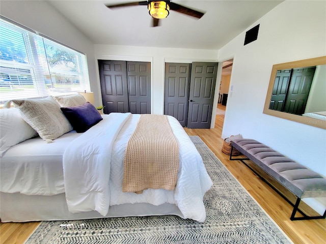 1373 Fairfax Rd, Clearwater, FL 33764 - bedroom featuring multiple closets, light wood-style floors, and ceiling fan
