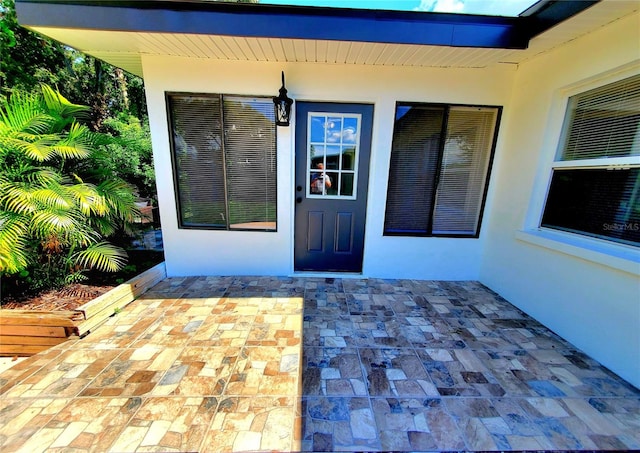 1373 Fairfax Rd, Clearwater, FL 33764 - view of exterior entry featuring stucco siding and a patio area