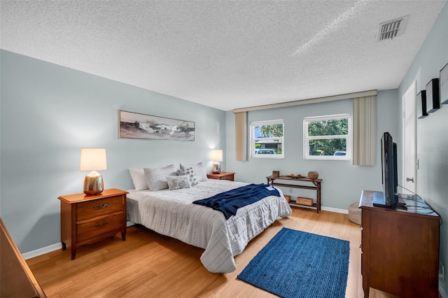 1400 Tarpon Woods Blvd Unit A4, Palm Harbor, FL 34685 - bedroom featuring light wood-style flooring, a textured ceiling, and baseboards