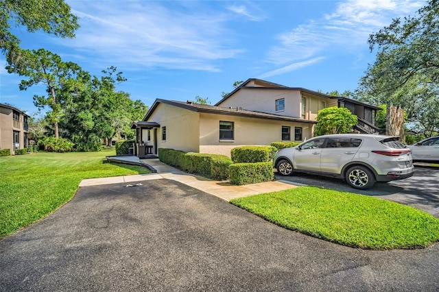 1400 Tarpon Woods Blvd Unit A4, Palm Harbor, FL 34685 - view of front facade featuring stucco siding and a front yard