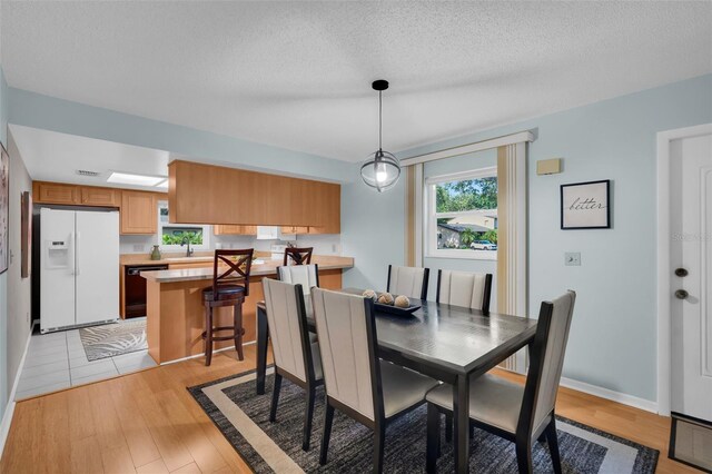 1400 Tarpon Woods Blvd Unit A4, Palm Harbor, FL 34685 - dining room featuring light wood finished floors and a textured ceiling