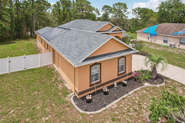 14494 Copeland Way, Brooksville, FL 34604 - view of property exterior with stucco siding, a gate, roof with shingles, and central AC unit