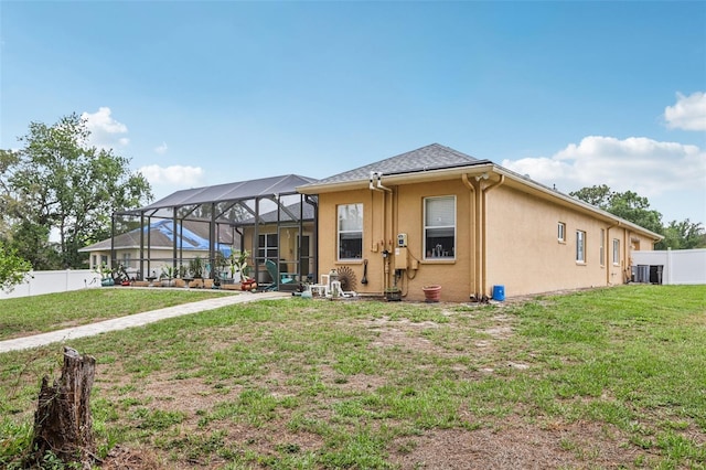 14494 Copeland Way, Brooksville, FL 34604 - back of house featuring stucco siding, glass enclosure, and central air condition unit