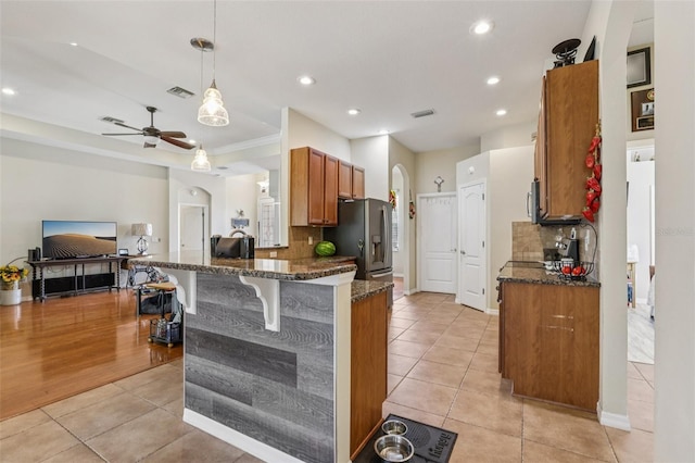 14494 Copeland Way, Brooksville, FL 34604 - kitchen featuring light tile patterned flooring, appliances with stainless steel finishes, decorative backsplash, brown cabinetry, and recessed lighting