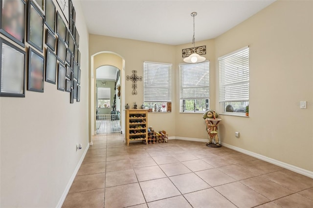 14494 Copeland Way, Brooksville, FL 34604 - dining space featuring arched walkways, healthy amount of natural light, light tile patterned floors, and baseboards