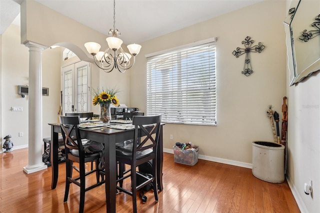14494 Copeland Way, Brooksville, FL 34604 - dining space with ornate columns, a chandelier, wood-type flooring, baseboards, and arched walkways
