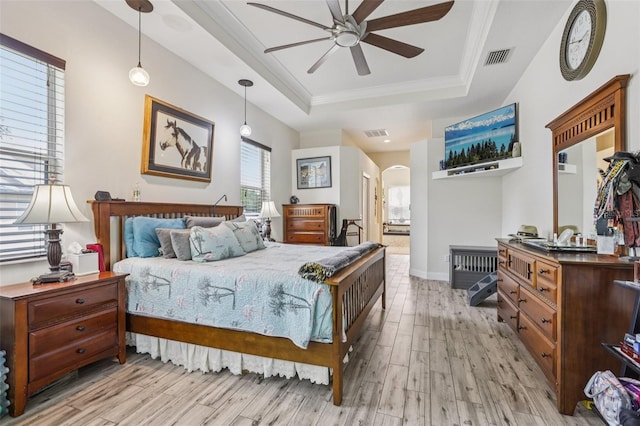 14494 Copeland Way, Brooksville, FL 34604 - bedroom featuring a tray ceiling, light wood finished floors, arched walkways, ensuite bathroom, and crown molding