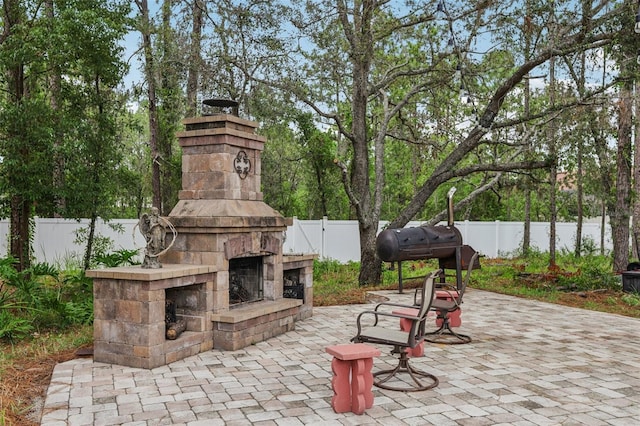14494 Copeland Way, Brooksville, FL 34604 - fenced backyard with an outdoor stone fireplace, a patio, and grilling area