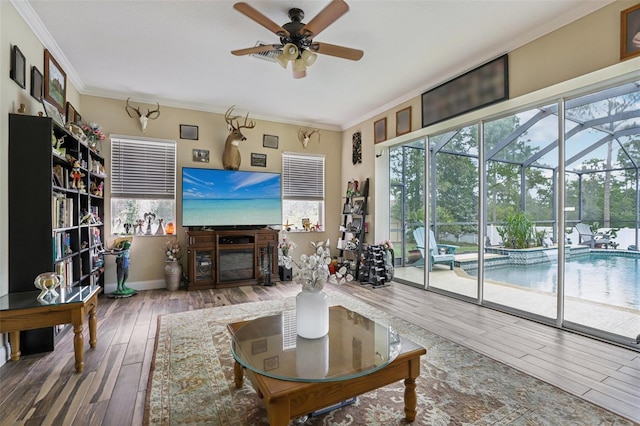 14494 Copeland Way, Brooksville, FL 34604 - living area with ceiling fan, hardwood / wood-style flooring, crown molding, a sunroom, and baseboards