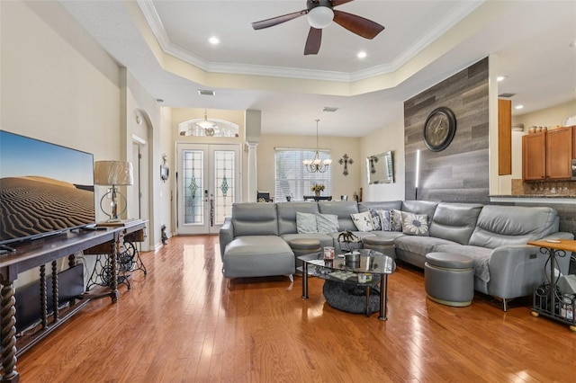 14494 Copeland Way, Brooksville, FL 34604 - living room featuring a raised ceiling, hardwood / wood-style flooring, a ceiling fan, a chandelier, and crown molding