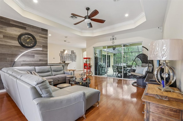 14494 Copeland Way, Brooksville, FL 34604 - living room featuring a ceiling fan, a tray ceiling, wood finished floors, recessed lighting, and crown molding