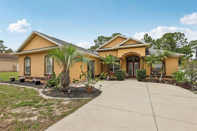 14494 Copeland Way, Brooksville, FL 34604 - view of front facade featuring stucco siding, driveway, french doors, and an attached garage