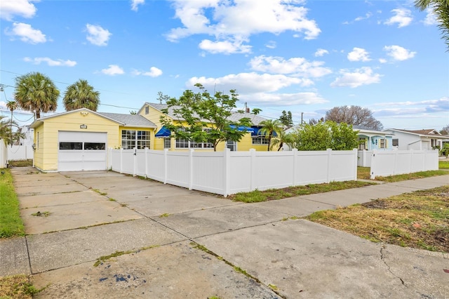 260 42nd Ave, St Pete Beach, FL 33706 - view of property exterior featuring driveway, a fenced front yard, and a garage