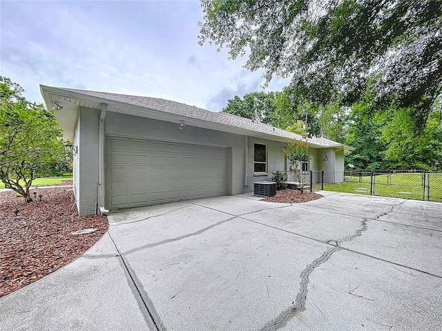 27511 Hialeah Way, Wesley Chapel, FL 33544 - view of front of home featuring driveway, stucco siding, central air condition unit, and a garage
