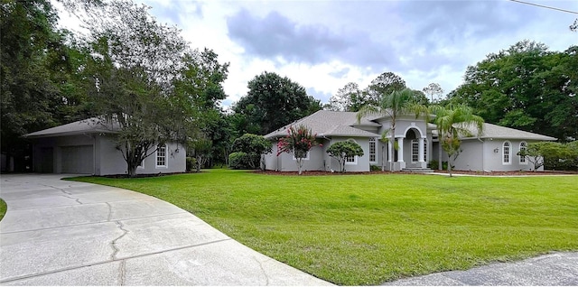 27511 Hialeah Way, Wesley Chapel, FL 33544 - ranch-style home with a front yard, concrete driveway, an attached garage, and stucco siding