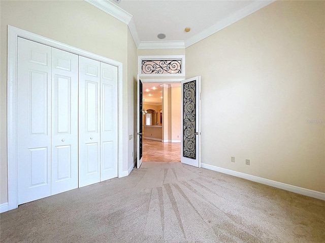 27511 Hialeah Way, Wesley Chapel, FL 33544 - unfurnished bedroom featuring ornamental molding, carpet floors, baseboards, a closet, and arched walkways