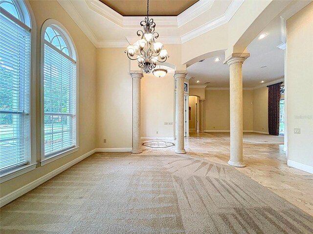 27511 Hialeah Way, Wesley Chapel, FL 33544 - unfurnished room featuring decorative columns, arched walkways, baseboards, crown molding, and a tray ceiling