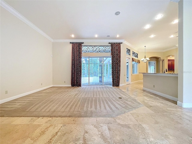 27511 Hialeah Way, Wesley Chapel, FL 33544 - unfurnished living room with ornamental molding, baseboards, arched walkways, recessed lighting, and a chandelier
