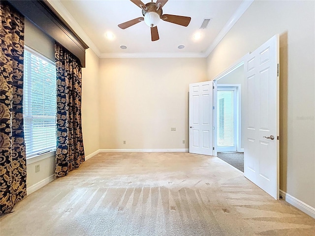 27511 Hialeah Way, Wesley Chapel, FL 33544 - unfurnished room featuring light carpet, crown molding, healthy amount of natural light, a ceiling fan, and baseboards