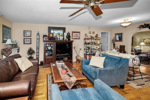 1151 Lancer Ln, Tarpon Springs, FL 34689 - living room featuring arched walkways, ceiling fan, and light wood finished floors